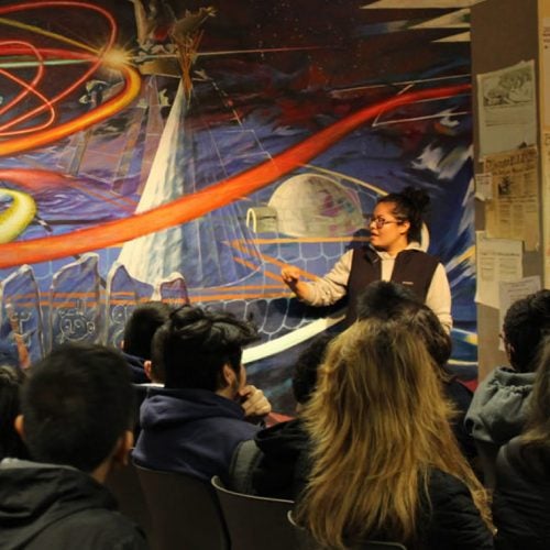 Staff at the Latino Cultural Center speaks to a crowd about a mural.