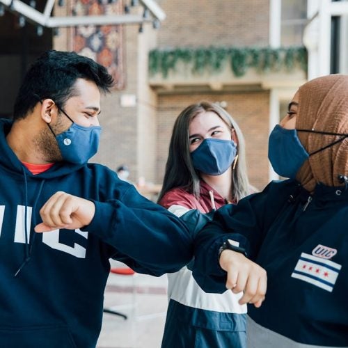 Students wear safety masks and bump elbows to congratulate themselves while preventing the spread of diseases.