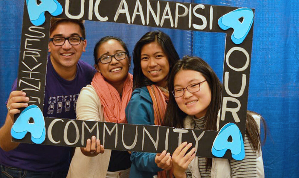 Four students framing themselves with AANAPISI cutout