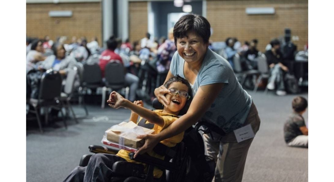 Child in wheelchair with woman.