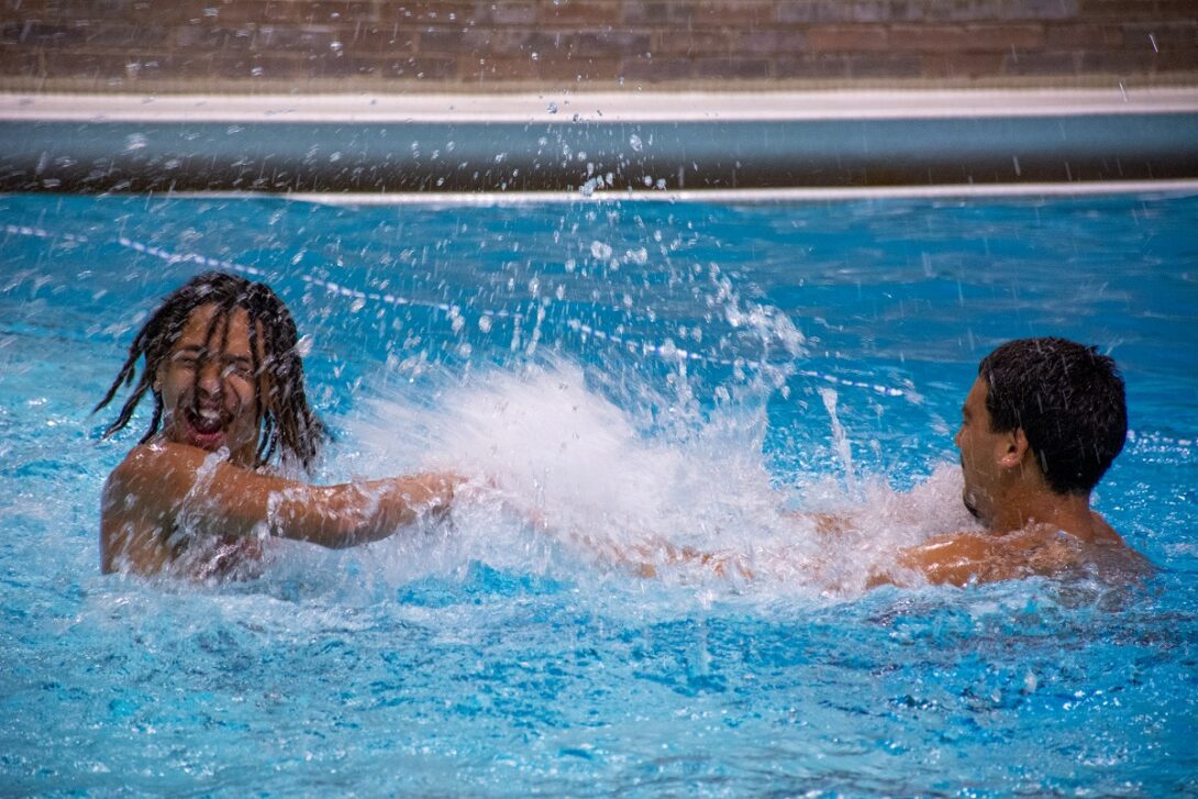 Two boys playing in the pool.