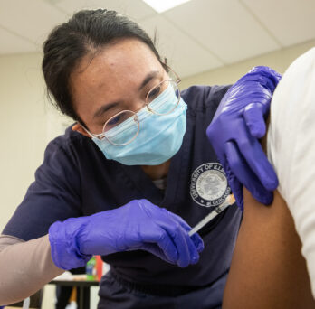 Nursing student administers a shot on a patient 