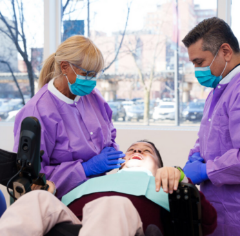 Clinicians performing dental work on a patient 