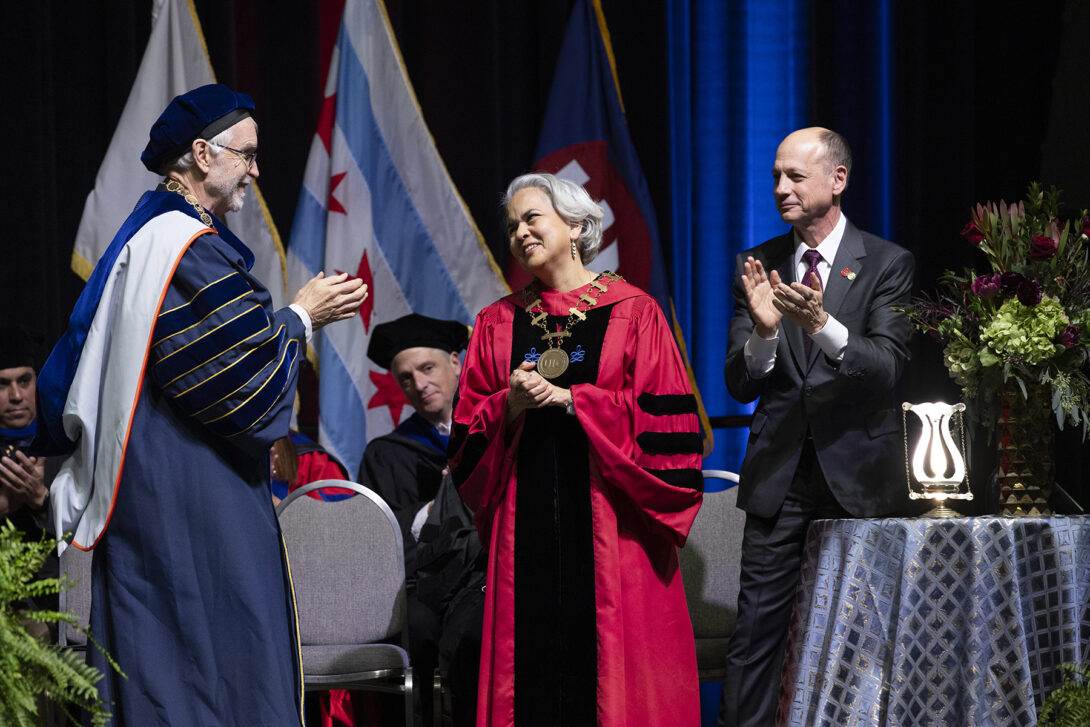 UIC Chancellor receiving applause on stage.