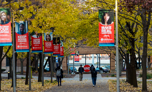 Students walking on campus under UIC banners